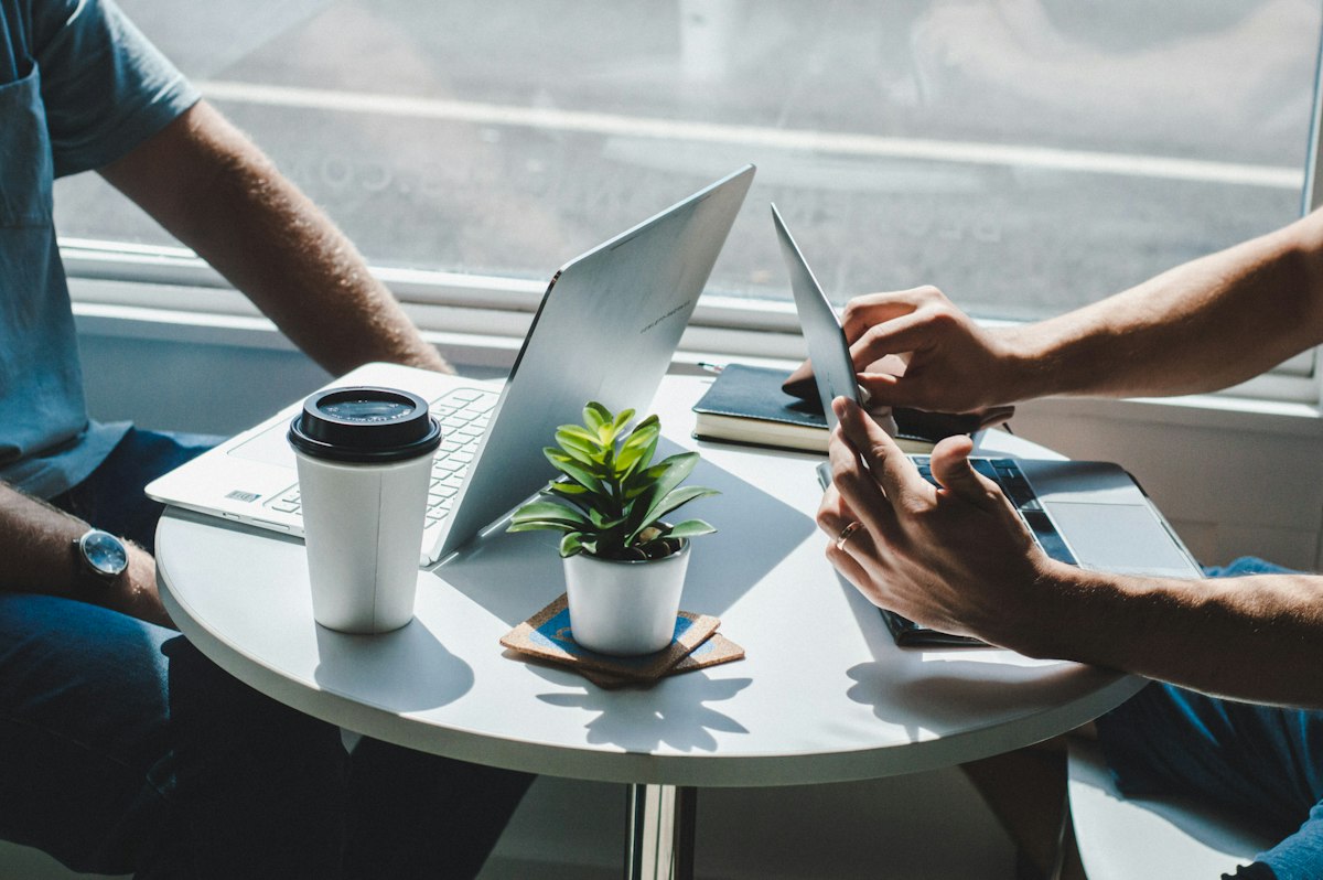 People working on laptops around a table