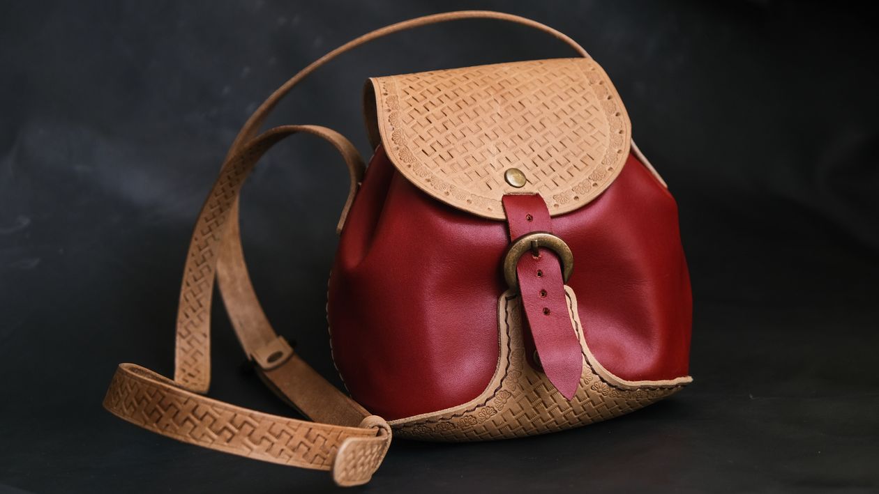 Close-up of a brown leather shoulder bag showing construction details